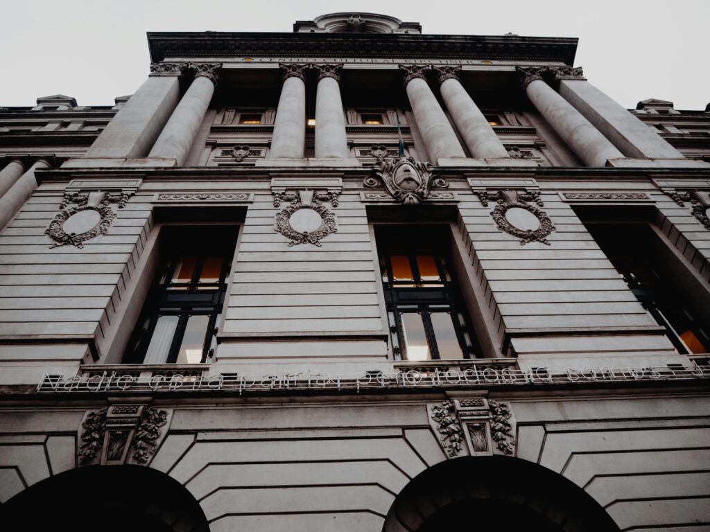 Low angle view of a neoclassical architectural facade showcasing detailed columns and decorative elements.